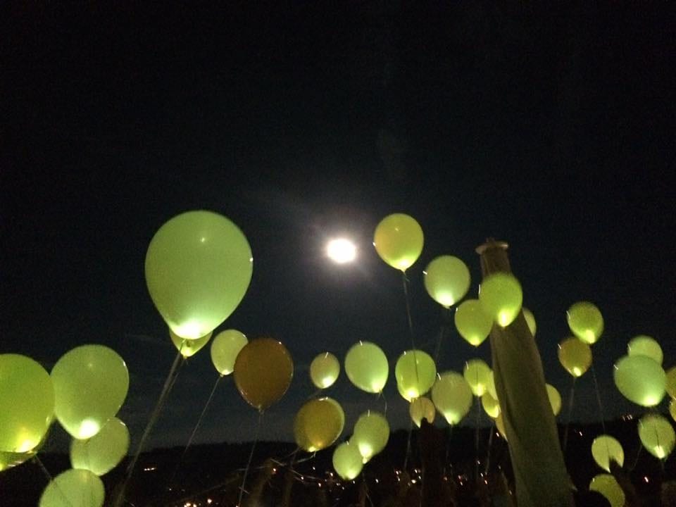 Leuchtende Ballons steigen in den Nachthimmel